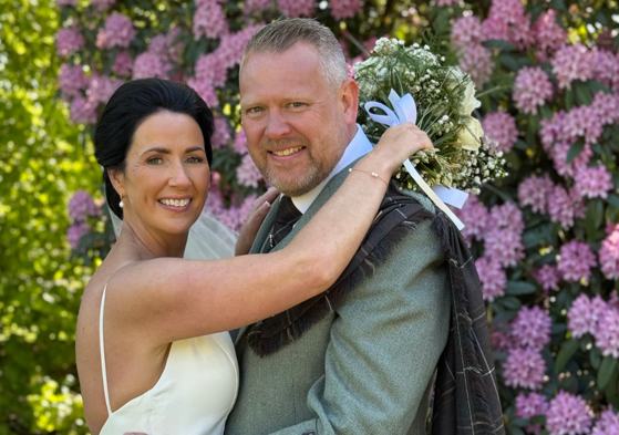 Wedding couple smiling at camera by Let's Do It Creative
